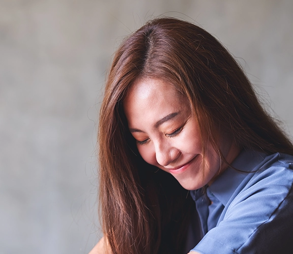 a portrait of a woman looking down and smiling