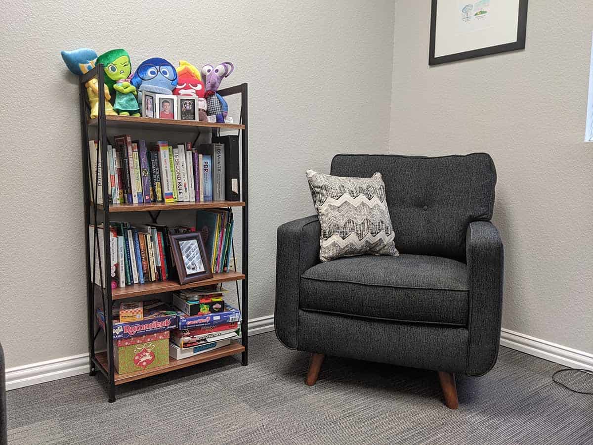 The interior of the See Me Therapy office showing a chair and bookshelf with kids toys