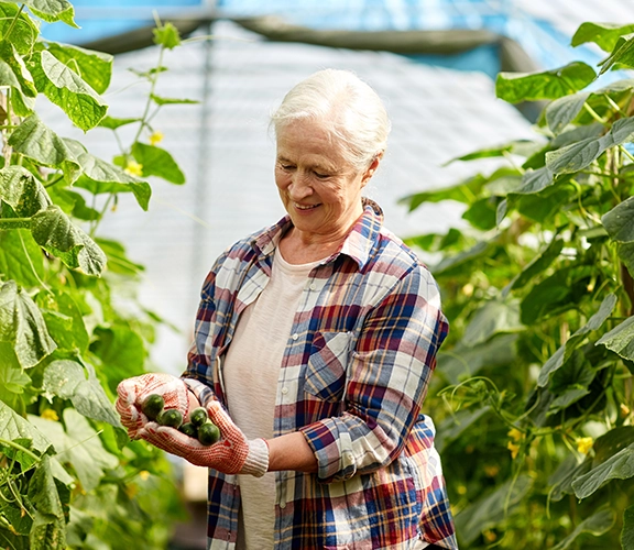 an older lading picking fruit in her garden